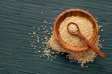 Chenopodium kinoası - Bir kase ve kaşıkta çiğ organik kinoa tohumu