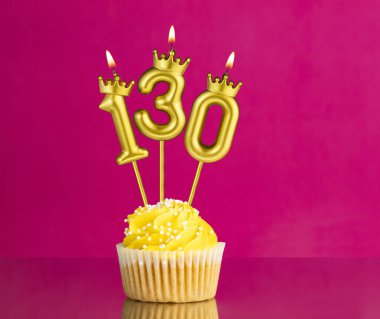 130 numaralı mumla doğum günü kutlaması - Pembe arka planda sarı kek
