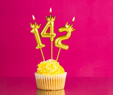 142 numaralı mumla doğum günü kutlaması - Pembe arka planda sarı kek