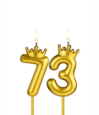 Beyaz arkaplanda 73 numaralı doğum günü mumu.