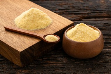 Tahta bir kaşık ve kase içinde buğday irmiği.