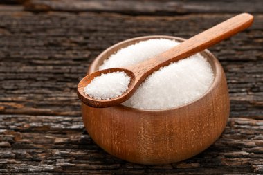 Saccharum officinarum - Tahta kaşık ve kase içinde rafine edilmiş beyaz şeker kristalleri