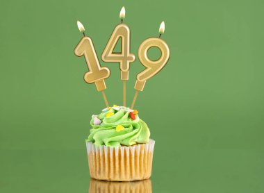 149 numaralı doğum günü mumu. Yeşil arka planda kek.