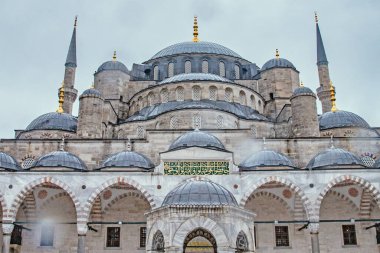 İstanbul, Türkiye 'deki Sultan Ahmed Camii' nin çarpıcı bir mimari fotoğrafı. Detaylı görüntü, sessiz gökyüzüne karşı bu ikonik simgenin karmaşık tasarımı, kubbeleri ve minareleri yakalar. Seyahat, mimari ya da kültürel proj için mükemmel.