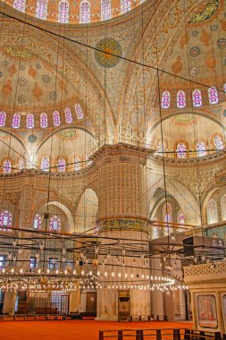 İstanbul 'daki Sultan Ahmed Camii' nin içi nefes kesici. Süslü detaylar duvarları ve kubbeyi kaplıyor. Karmaşık tasarımlar ve vitraylı pencereler ihtişamı artırıyor. Devasa sütunlar yüksek tavanları ve zarif ışık bağlantılarını destekliyor.
