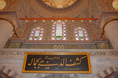 Nefes kesen bir yukarı bakış açısı, İstanbul 'daki Sultan Ahmed Camii' nin zarifliğini gözler önüne seriyor. Mimaride karmaşık detaylar, vitray pencereler, ve altın bir plaketteki süslü el yazısı büyüleyici bir güzellik ve spir manzarası yaratıyor.