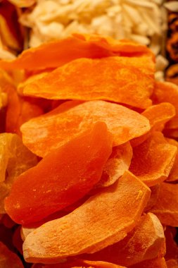 Canlı portakallı kurutulmuş mango dilimlerinin yakın çekim görüntüsü. Doku biraz şekerli ve rengi de sıcak görünüyor. Bu ayrıntılı resim meyvelerin ayrı ayrı parçalarını gösteriyor.