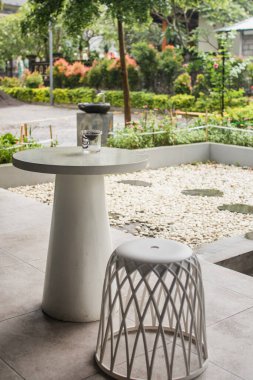 Handmade white chair and dinning table with aesthetic garden background. Coffeeshop concept