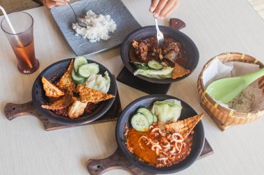 Sambal gami cumi veya sambal ile pişirilmiş ahşap arka planda toprak kaplama. Tahta masada servis edilir.