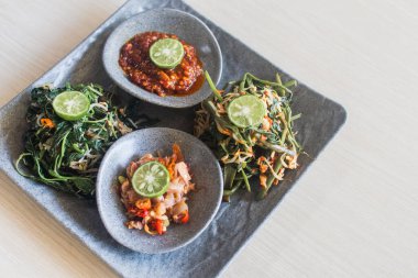 Kangkung Pelecing ya da domates soslu ıspanak ahşap masa üstü manzaralı - Endonezya, Bali 'de sebze yemeği