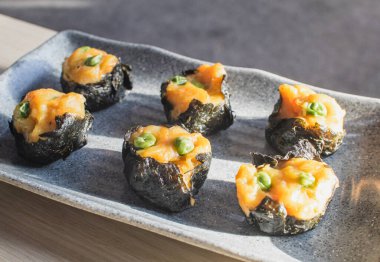 Ahşap masa üzerinde acı biber, domates ve sosla servis edilen buğulanmış gamsum.