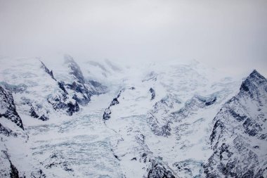 Foggy view of ridge of European Alps in winter, ski resort Chamonix Mont-Blanc, France. Ideal place for extreme sport and hiking. Winter activity. Natural background