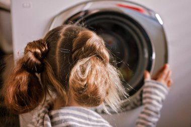 Eco-conscious teenage girl using common laundry to save resources and money. Sustainability and environment care. Conserving water, energy and natural resources. Eco-lifestyle in action