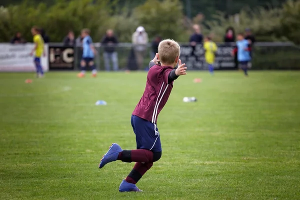 年轻的足球运动员张开双臂冲向球场 进球后散发出纯粹的喜悦和胜利 年轻的体育活动 — 图库照片
