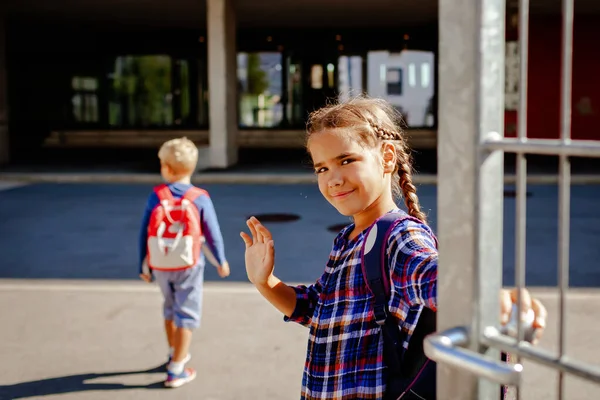 回学校去快乐的女孩 背着背包 小学生 第一天在学校附近挥手 学习和教育 度假后团聚 生活方式 — 图库照片