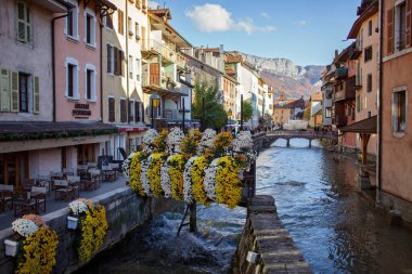 Annecy 'de sonbaharda dar bir kanal manzarası. Antika kafeler, köprüler, bol çiçekler, Fransa 'nın ortaçağ turizm merkezindeki tarihi evler.