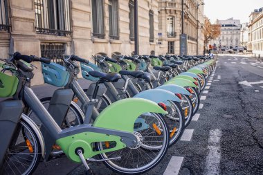 Paris, Fransa 'nın bir caddesinde kiralanmak üzere elektro bisikletler, paylaşım noktası, şehir ulaşımı ve çevresel bilinçli seyahat seçimi, ekolojik ulaşım kavramı