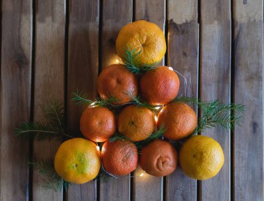 Mandallardan ve çam dallarından yapılmış Noel ağacı ahşap bir arka planda, üst manzara