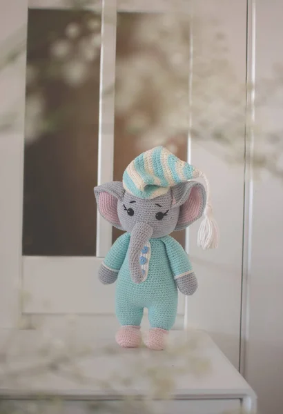 handmade knitted elephant toy in blue pajamas
