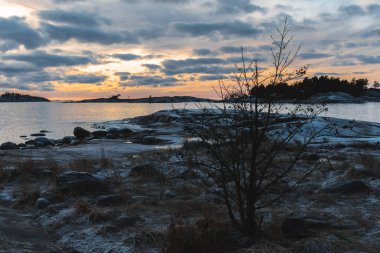 beautiful yellow sunset, cloudy sky, rocky coast