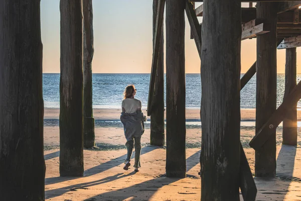 stock image woman walks along the beach at sunset