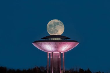 Finlandiya, Espoo 'da bir restoran binasının üzerinde gece gökyüzünde kocaman bir dolunay var.