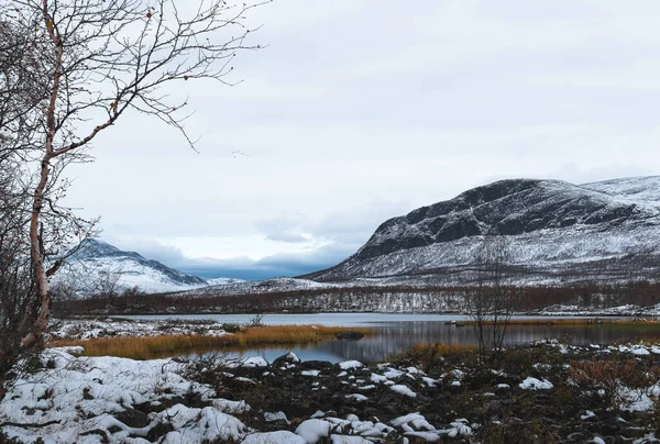 stock image Beautiful winter landscape with lake and mountains in the north of Finland