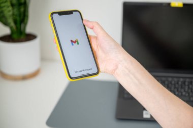 Espoo, Finlandiya - 29 Ekim 2024: Google uygulamalı iPhone 'u evde mobil uygulama kullanarak ekranda tutan kadın