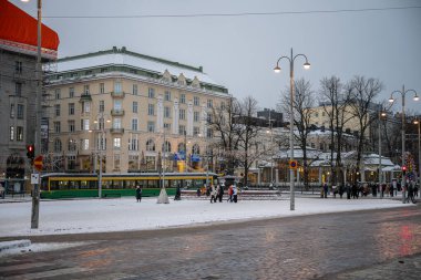Helsinki, Finlandiya - 23 Kasım 2024: Avrupa meydanı, tramvay geçişi, yaya geçişi, tarihi binalar, karlı zemin ve bulutlu gökyüzü