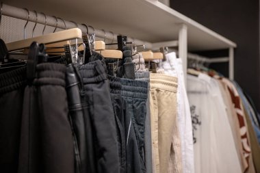 İkinci el mağazasında raflarda farklı renkte pantolonlar düzenleniyor.