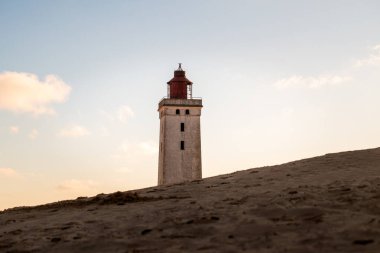 Kumlu kumulda terk edilmiş deniz feneri gün batımında, Rubjerg Knude, Danimarka