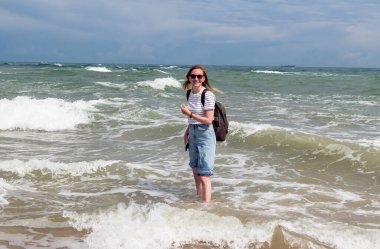 Sırt çantalı genç kadın Kuzey Denizi ve Baltık Denizi 'nin birleştiği yerde duruyor, Skagen, Danimarka