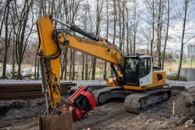 Şehir şantiyesinde çalışan ağır sarı kazıcı. 