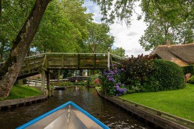 Hollanda 'daki ünlü Giethoorn köyünün manzarası. Kanalları ve ahşap köprüleri var.. 