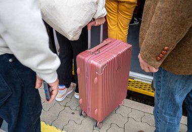 Seyahat sırasında istasyonda pembe valizli insanlar trene biniyor.. 