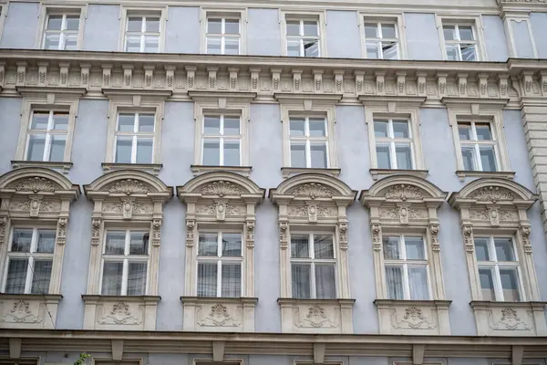 Süslü pencereler ve klasik taş ayrıntılarıyla tarihi Avrupa binası cephesi. 