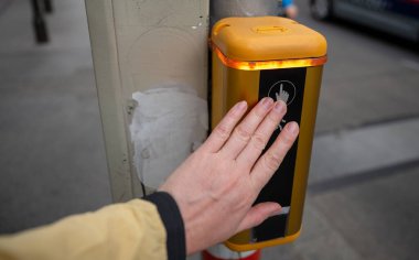 Şehir caddesinde yaya geçidinde trafik sinyal direğinde düğmeye basan yaya.. 
