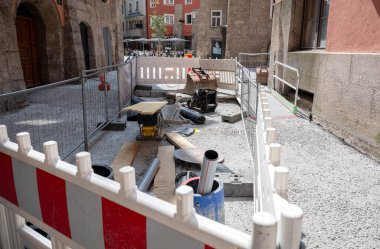 Eski Avrupa şehir merkezinde alet ve borularla donatılmış inşaat sahası.