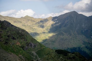 Avusturya Alpleri 'ndeki dağların üzerinde dramatik gölgeler bırakan güneş ışığı. 