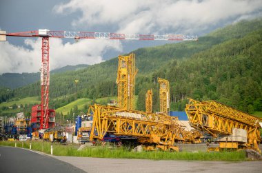 Dağ manzarasındaki malzeme deposunda vinç ve makine yapımı..