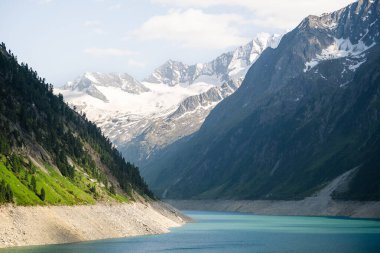 Buzul kaplı dağları ve yazın yemyeşil yamaçları olan Alp Gölü