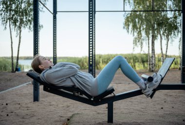 Yazın göl kenarındaki spor salonunda egzersiz yapan genç bir kadın.. 