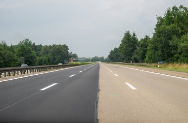 Otoyolun bir kısmı yeni döşenmiş, diğer kısmı hala eski yüzey, kısmen yüzeye çıkmış asfalt yol.. 