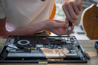 Bilgisayarı masadaki araçlarla tamir eden adam, bilgisayar bakım konsepti. 