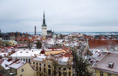 Karlı çatıların ve Tallinn 'deki Aziz Olaf kilisesinin kış panoramik manzarası. 