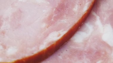 Jambon ince dilimlere bölünmüş. Dilimlenmiş sosis yarım daire şeklinde dizilir. Makro video. Yüksek kalite 4k görüntü