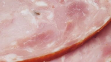 Jambon ince dilimlere bölünmüş. Dilimlenmiş sosis yarım daire şeklinde dizilir. Makro video. Yüksek kalite 4k görüntü