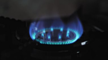 Karanlık bir odada gaz sobası kapanıyor, yakıtı bitiyor. Gaz ocağından mavi alevi söndürmek. Yüksek kalite 4k görüntü