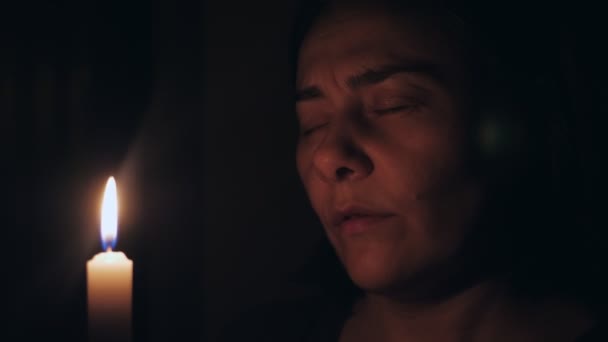 Кавказька Жінка Молиться Закритими Очима Перед Вогняною Свічкою Дівчинка Шепоче — стокове відео