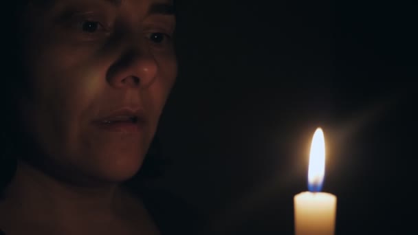 Белая Женщина Молится Стоя Перед Горящей Свечой Девушка Смотрит Свечу — стоковое видео
